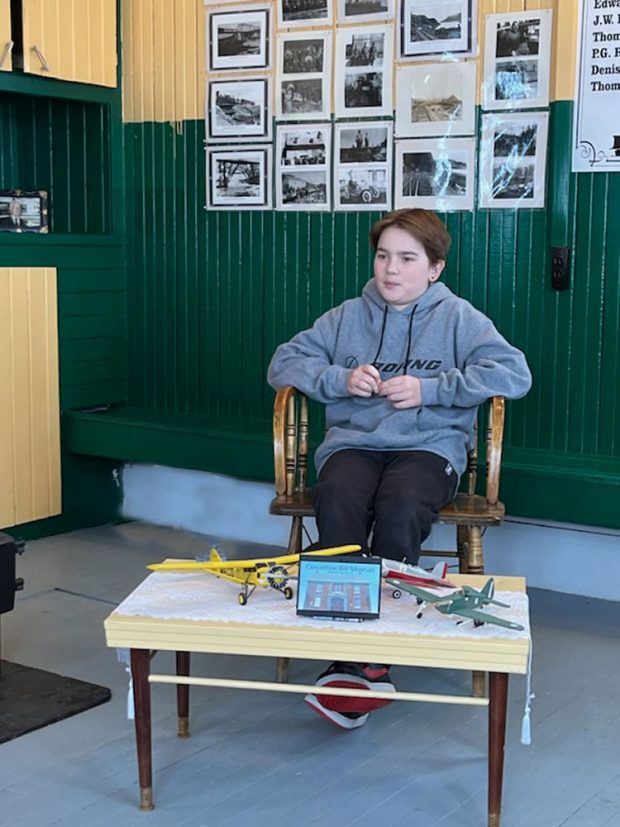 A coloured photo of Austin Thorne sat in a chair being interviewed.