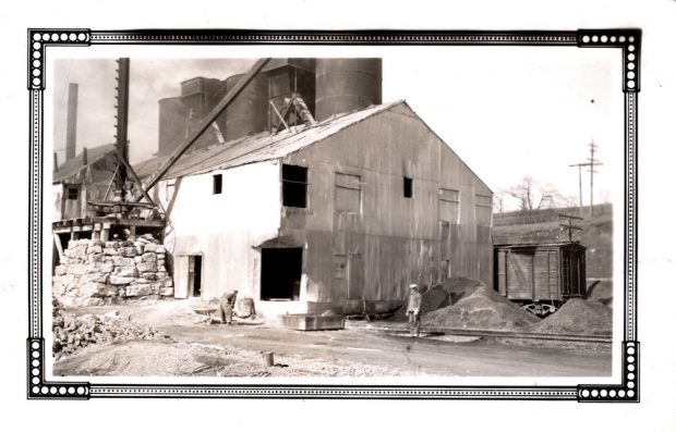 Two people outside of Innerkip Lime and Stone with a train car visible on the right