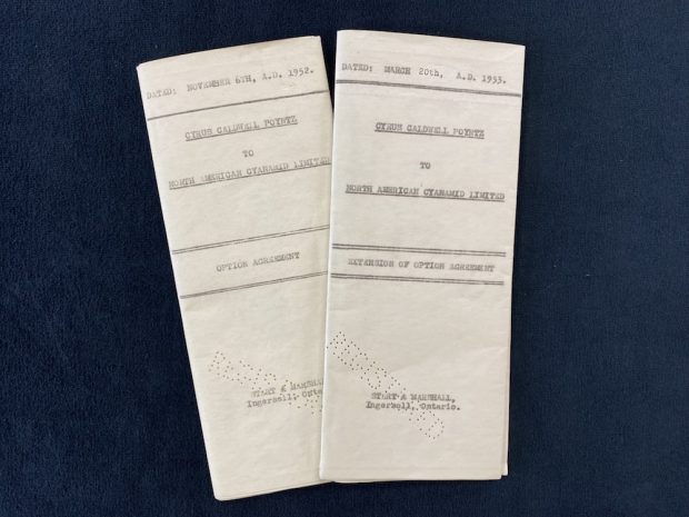 Two, folded documents with type-written dates and headings on the front and the punched word, REGISTERED, at the bottom