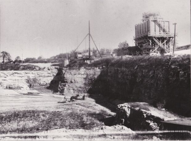 Black and white image of Standard White Lime quarry pit with horse and worker at bottom