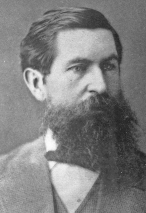 Black and white photographic portrait of Doctor William Mostyn, a man with dark hair and a beard wearing a suit.