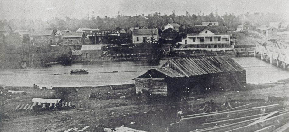 Black and white photograph of a sawmill in Almonte, c. 1850, with the Mississippi River and town of Almonte in the background.