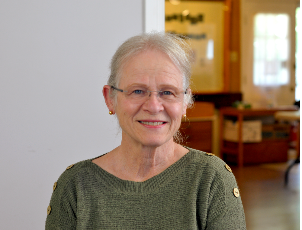 Colour photographic portrait of Dr. Christiane Deschenes. She has glasses and grey hair, and is wearing a green shirt.