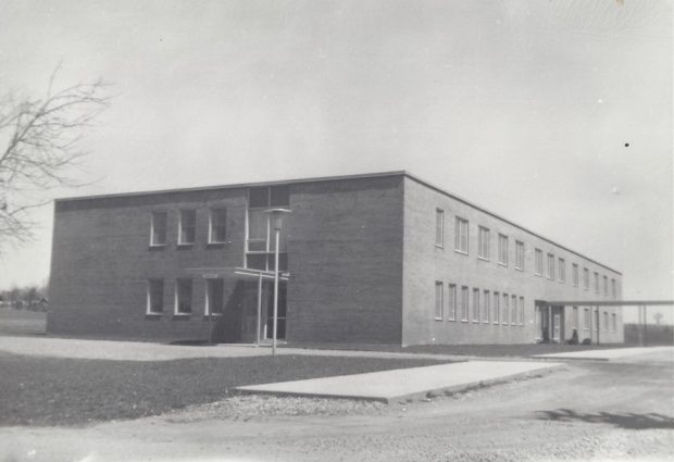 Black and white photograph of a hospital. It is a rectangular, two-storey brick building.