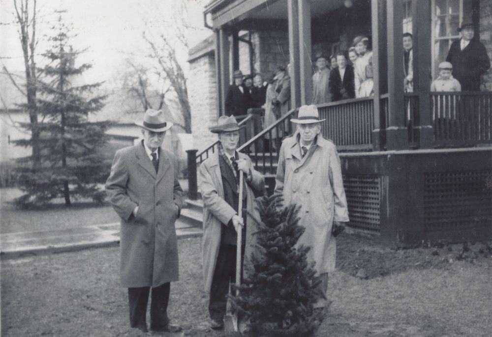 Black and white photograph of Dr. Dunn, Dr. Metcalfe and Dr. Kelly in front of the Rosamond Memorial Hospital during a tree planting ceremony on April 25, 1953.