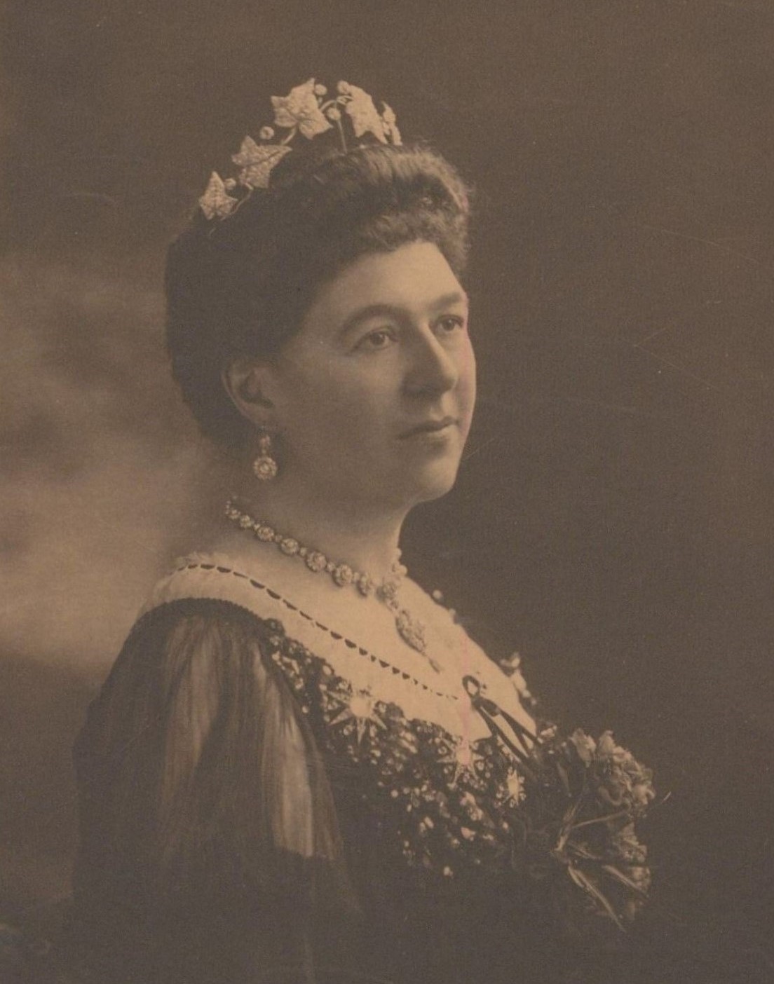 Sepia of photograph of Lady Aberdeen, a woman with dark hair wearing a dress, necklace and earrings.