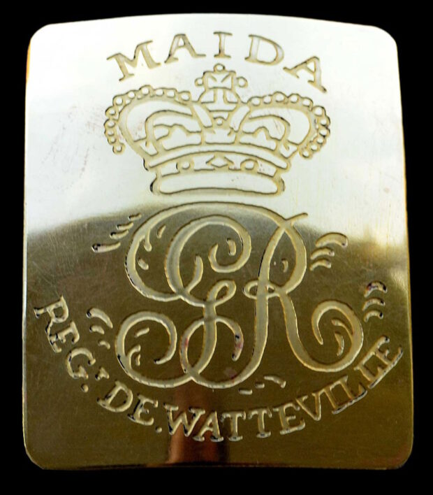 Gold rectangular belt plate embossed with the letters GR and the word Maida.