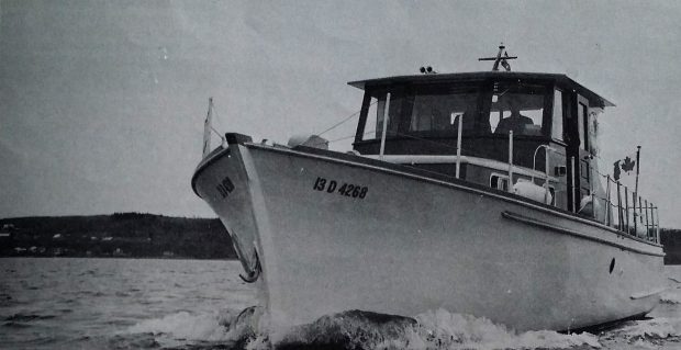 Black and white photograph of a small yacht seen from the front, sailing on the river. A man wearing a hat is at the controls in the cabin. A Canadian flag flies at the back. La Bernache, 1968. Ministry of Hunting and Fishing »