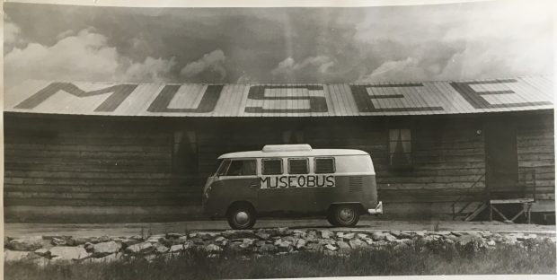 Black and white photo of a van marked “Muséobus” parked in front of a building bearing the word “Musée” in large letters.