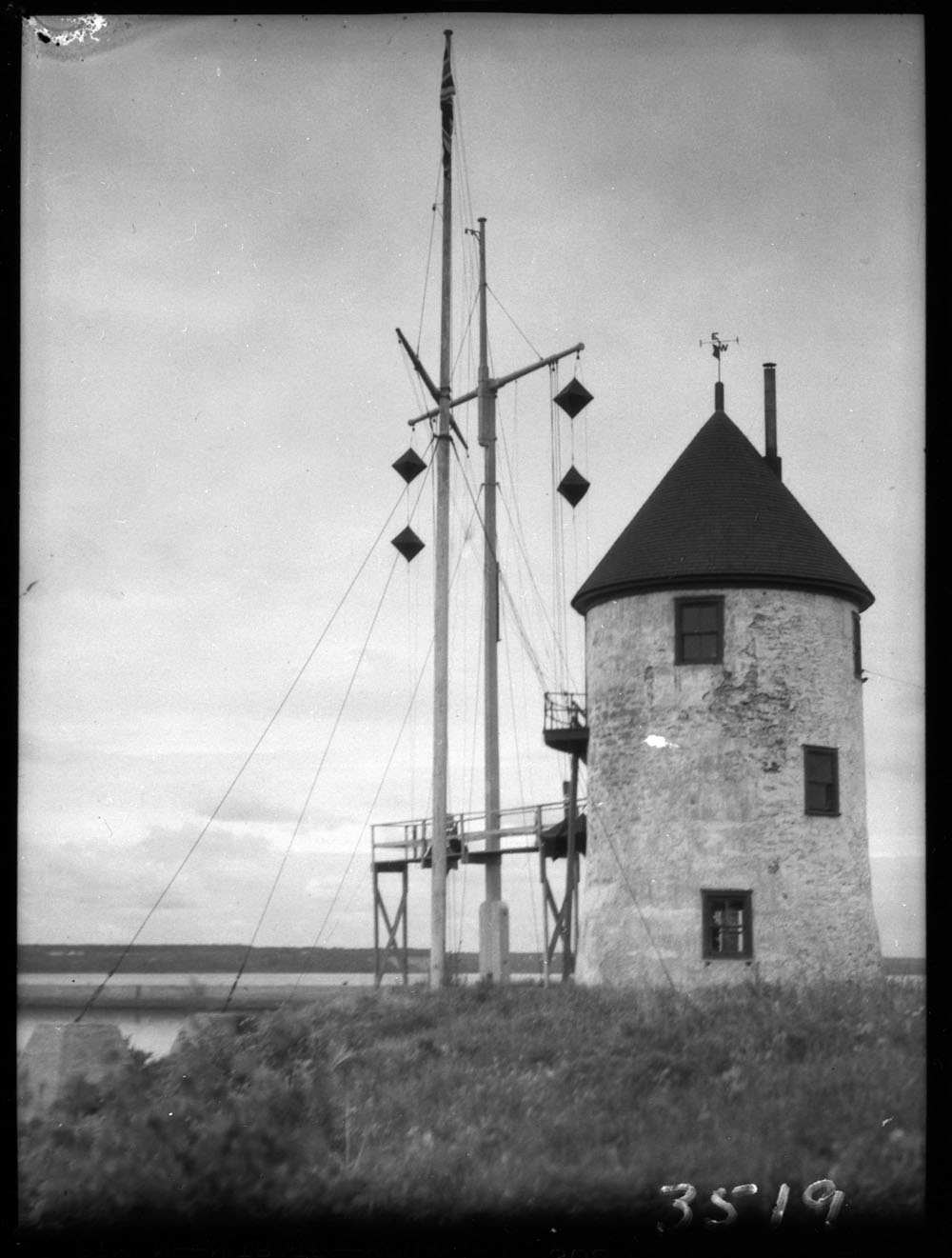 Black and white photo of the wingless windmill with two masts.