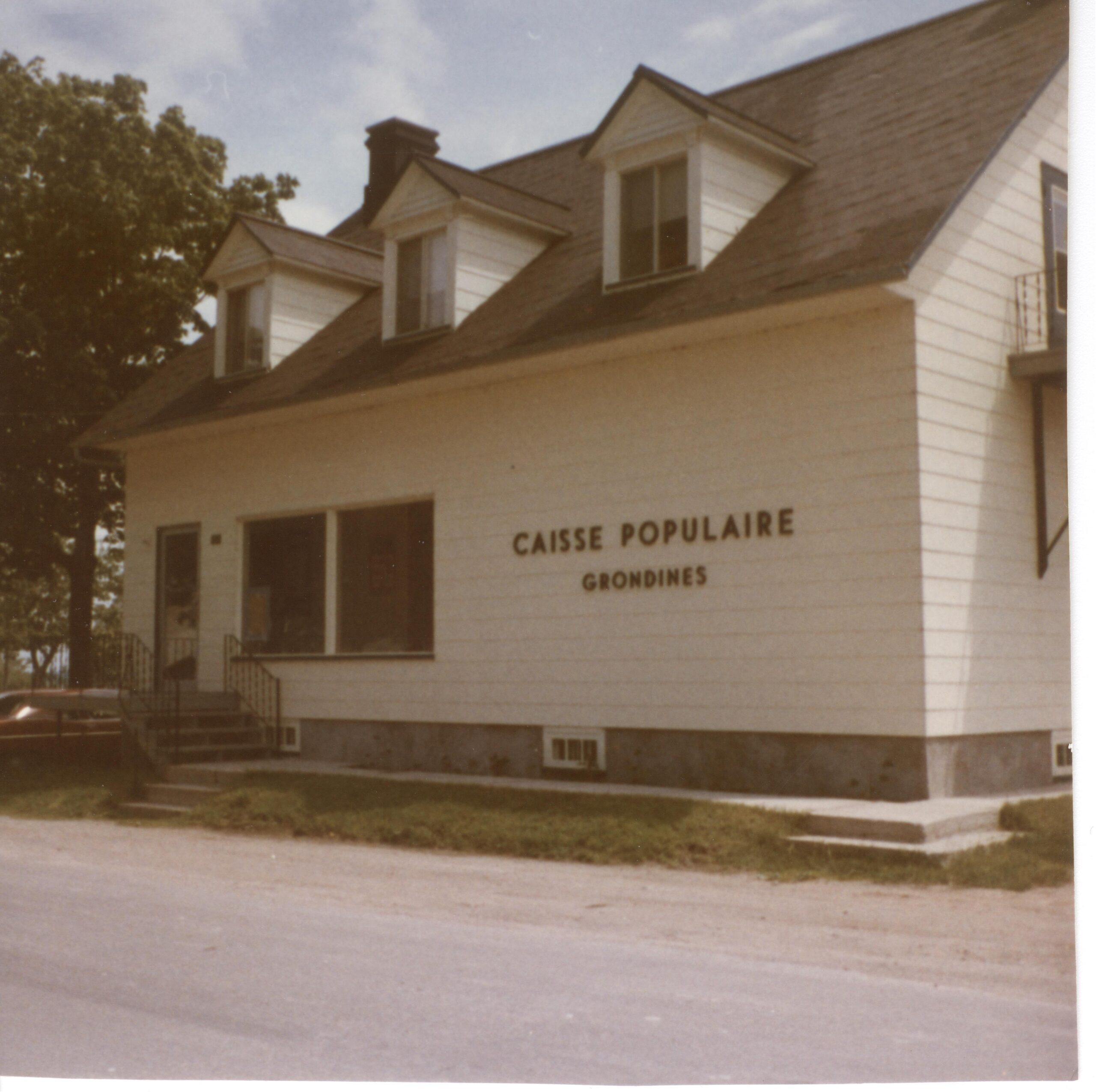 Small white house reading “Caisse populaire - Grondines”.