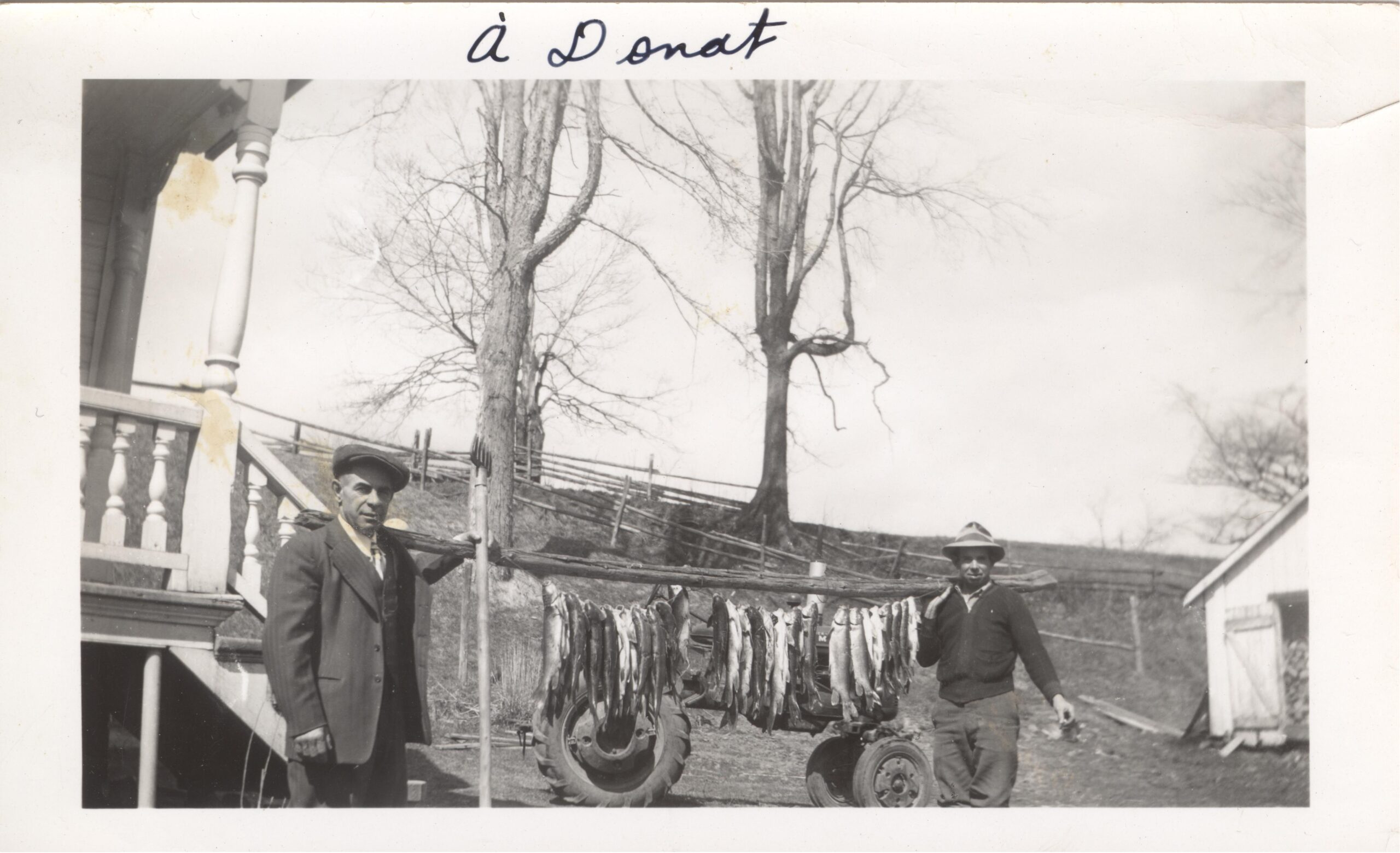 Black and white photo of two men with their fishing catch.