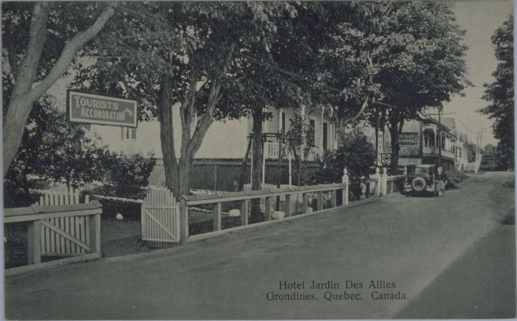 Black and white photo of a road and a hotel storefront.