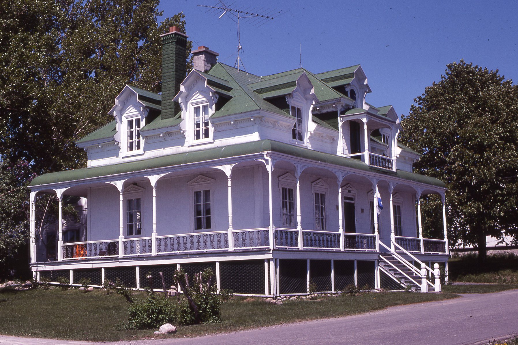 White house with green four-sloped roof.