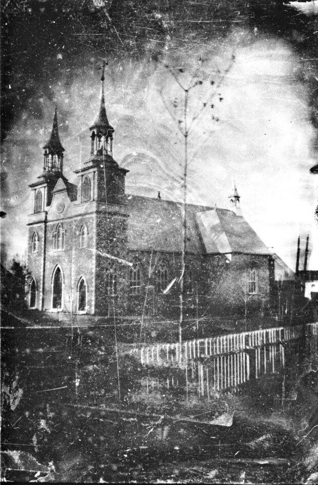 Black and white photo of the church with its first symmetrical bell towers.