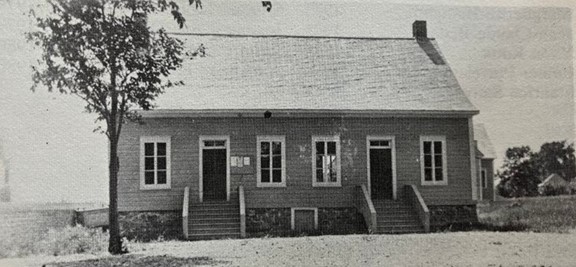 Black and white photo of a building with two doors and two symmetrical staircases.