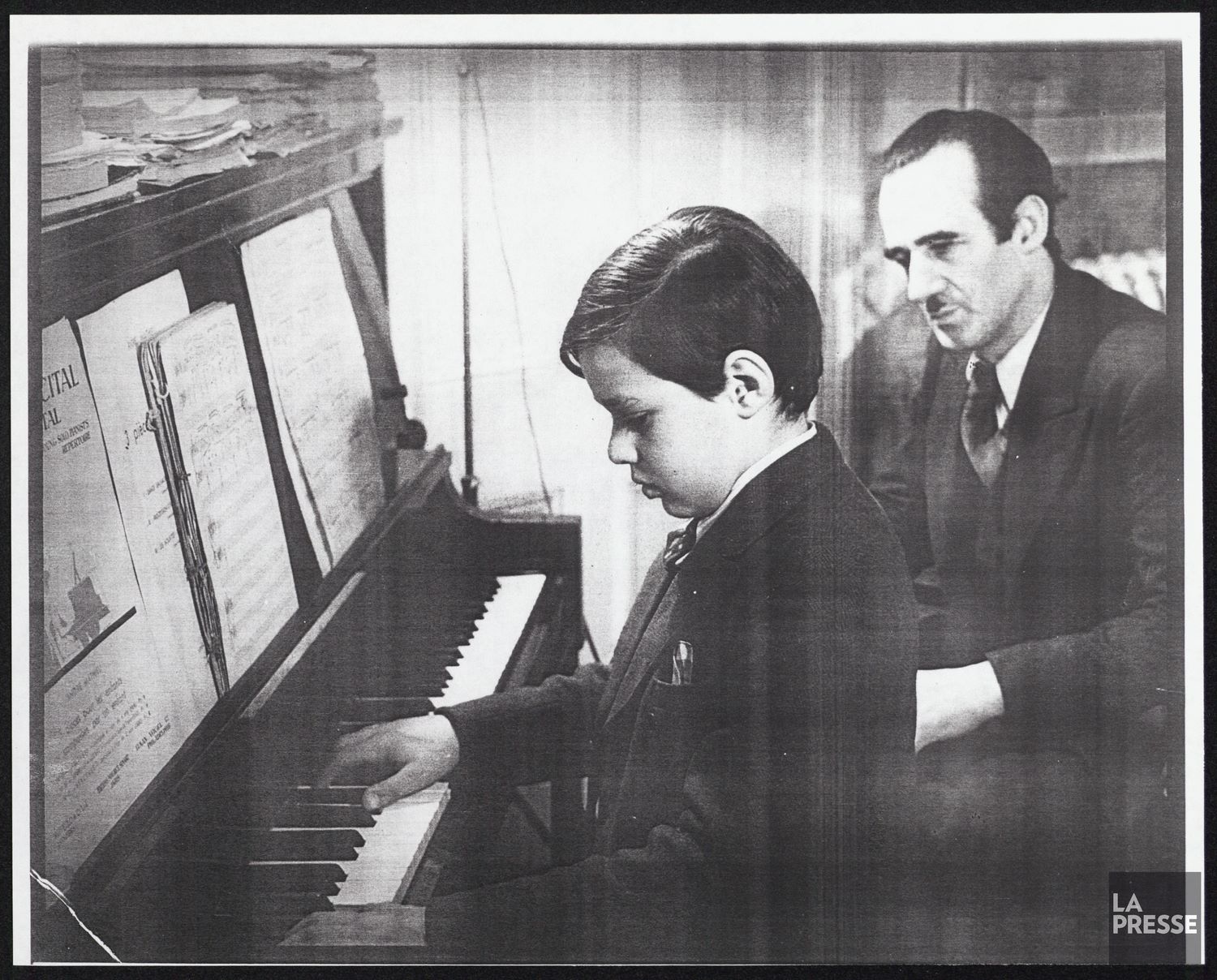 Black and white photo of André Mathieu seated at the piano with his father Rodolphe.