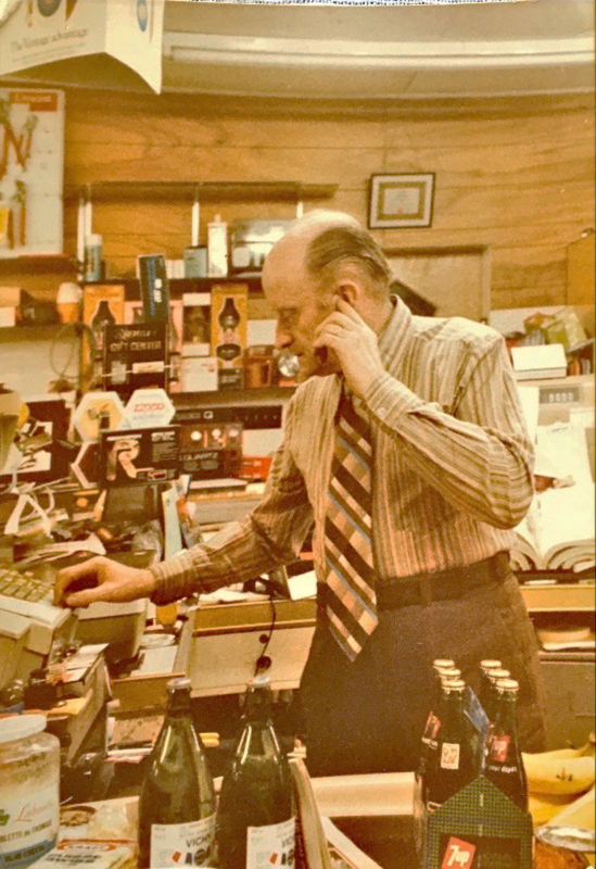 Photo of a man at the cash counter of a general store.