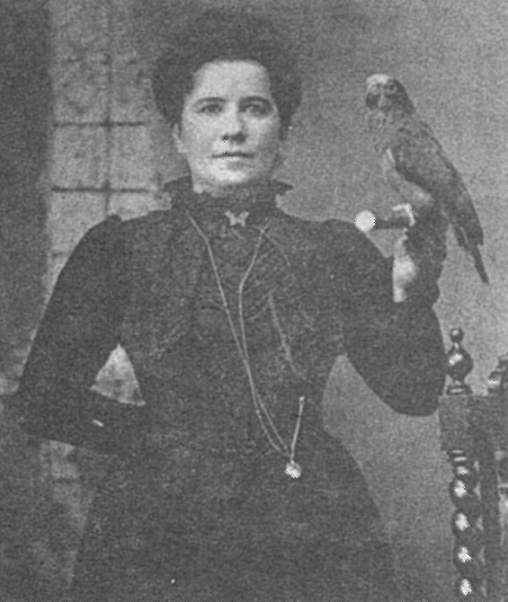 Photo of Queen Lill holding a parrot in her hand.
