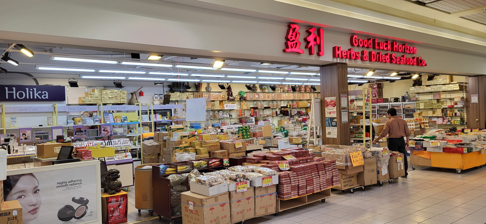 A busy shop inside Agincourt Mall with stacked boxes with herbs and dried goods on display.