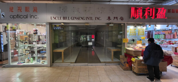 Indoor view of a mall corridor with closed and operational shops with a person passing by