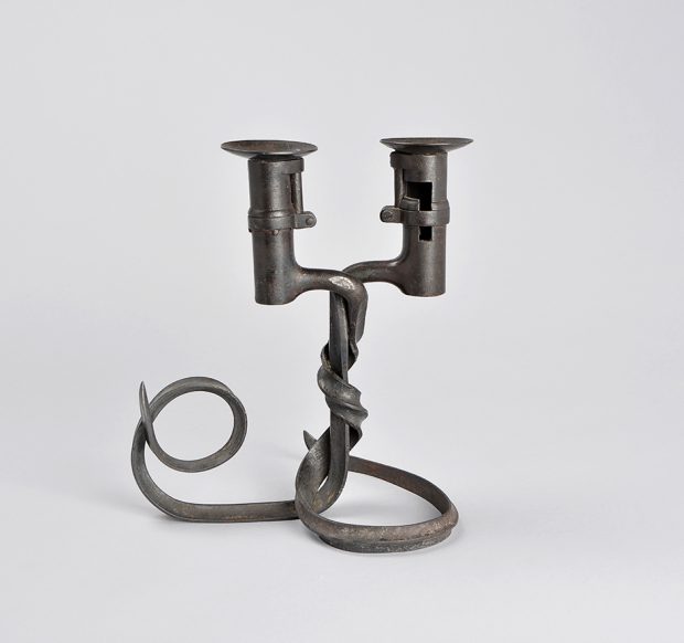 Two side by side candle holders atop entwined bayonet bases