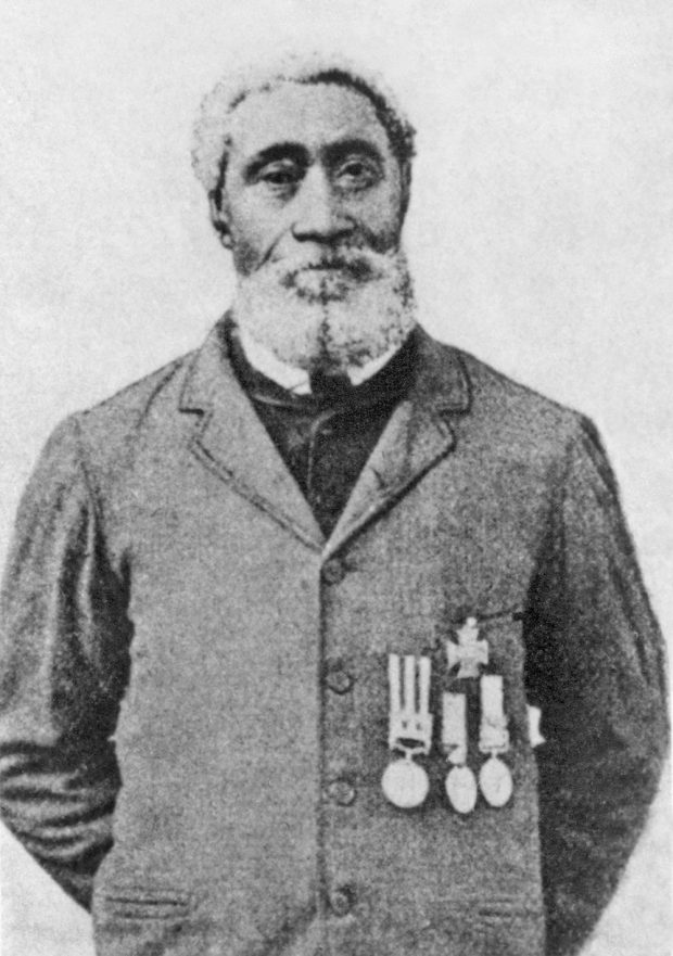 A black and white image of a black soldier wearing his medals on his civilian clothes