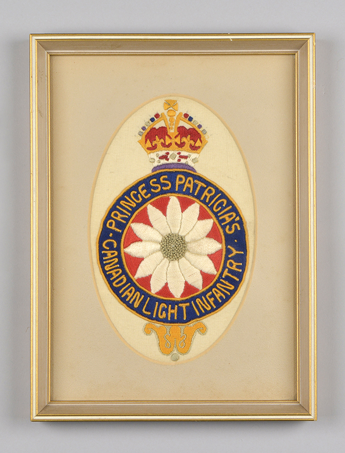 A framed colourful and detailed hand-embroidered Princess Patricia’s Canadian Light Infantry crest in an oval tan matte.