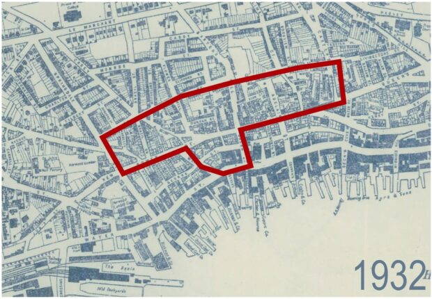 Aerial map of downtown St. John’s with 1932 in the bottom right corner. A red line outlines a particular area which includes part of Springdale Street along John Street, and Central Street to Carter’s Hill across New Gower Street down Queen Street across Water Street and up Waldegrave Street. The red bordered section is highlighting the location of redevelopment.