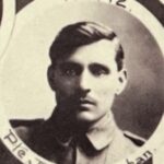 Sepia portrait of a man with dark hair, moustache, and eyes wearing a military uniform. The portrait is circular with the words No 712 Pte Joseph Sheehan around the portrait. There are other partial circular photos in the background on a black paper background.