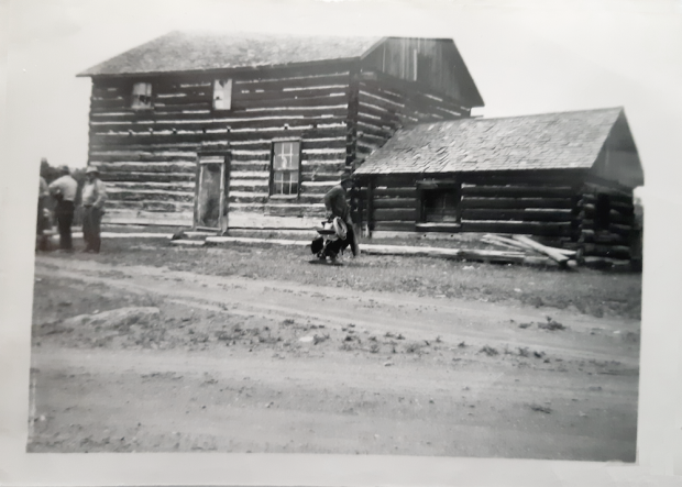 Men in front of wooden cabin