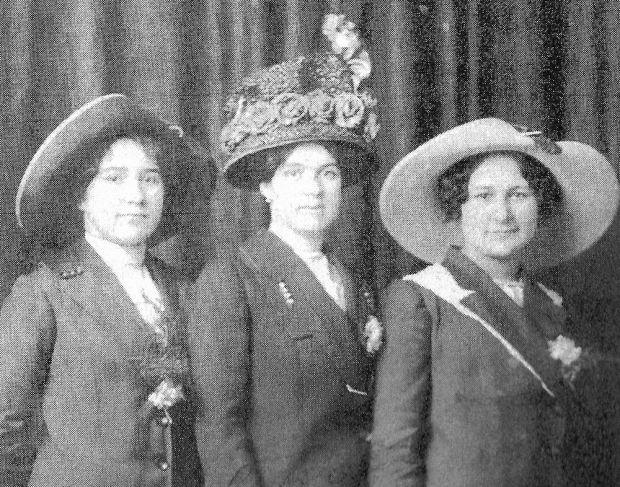 Three women wearing coats and hats