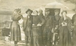 8 men and women standing in front of building