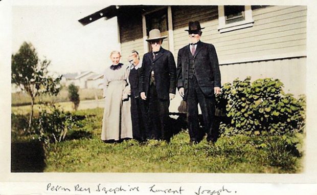Two men and two women standing in front of a house