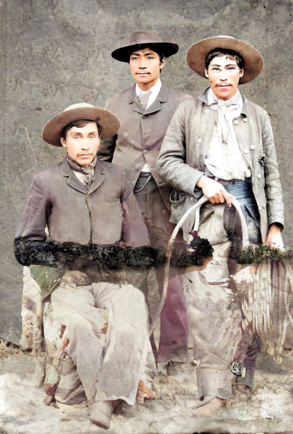 Studio photo of three cowboys in gear