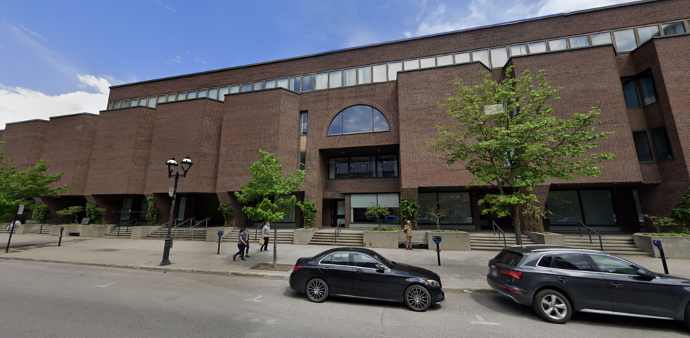 Color photograph from Google Streetview. It shows the facade of a brown brick building in a modern style close to brutalism.