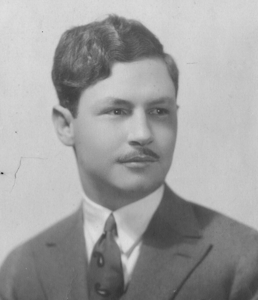 Black and white photographic portrait of a man in a suit.