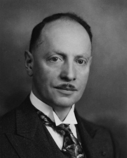 Black and white photographic portrait of a man in a suit.