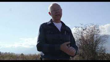 Bruce Tillen – a bald white man, wearing a white shirt and blue and black jacket. He is standing outside.