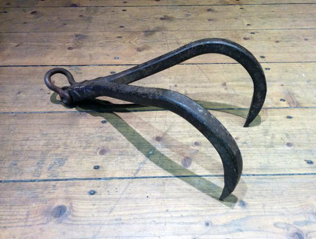 A steel stump puller made of two pieces of hooks joined together with a moving eyehook.