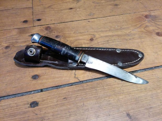 Picture of a hunting knife and its leather case.