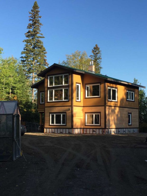 View of a newly built, two-story house surrounded by trees.