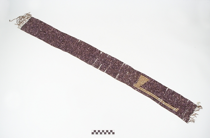 Belt with woven pearls, long rectangular shaped, with purple and white stains. We can see the shape of an axe as decoration.