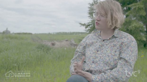 Exterior shot of a seated person with an agricultural field in the background.