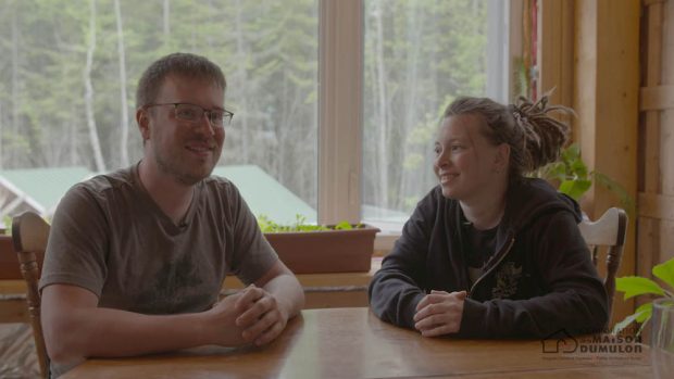 Interior shot of a man and a smiling woman around a table.